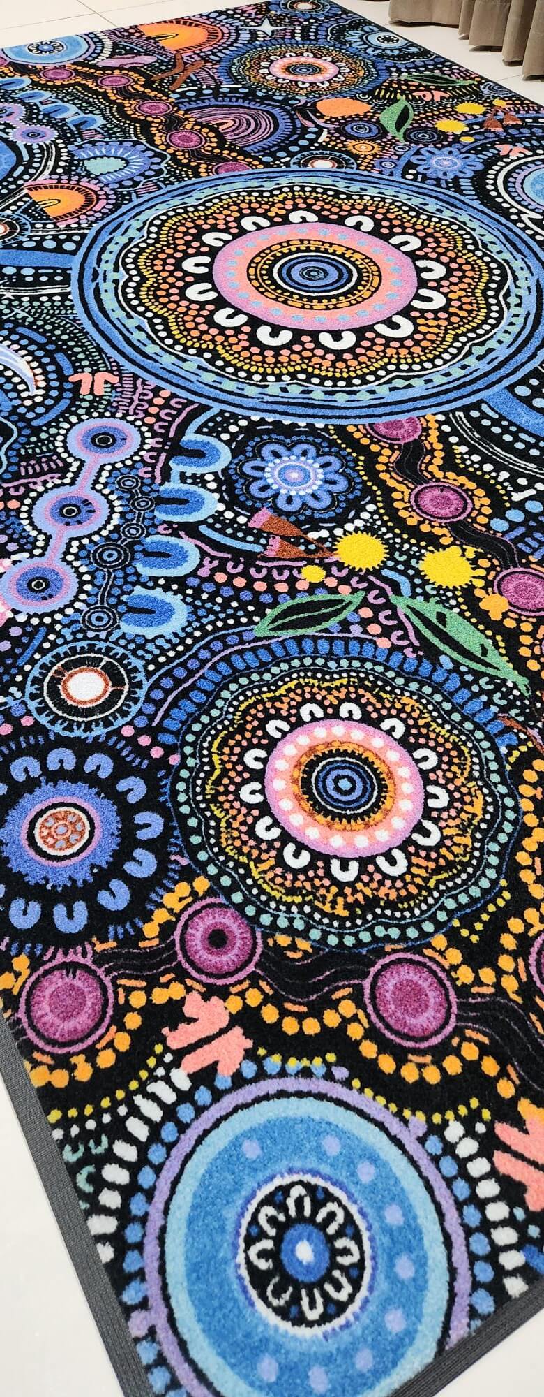 Ngulawaa classroom rug by Kirsten Gray, 2m x 3m, with vibrant Indigenous design, non-slip backing and non-trip edges. Close up on angle.
